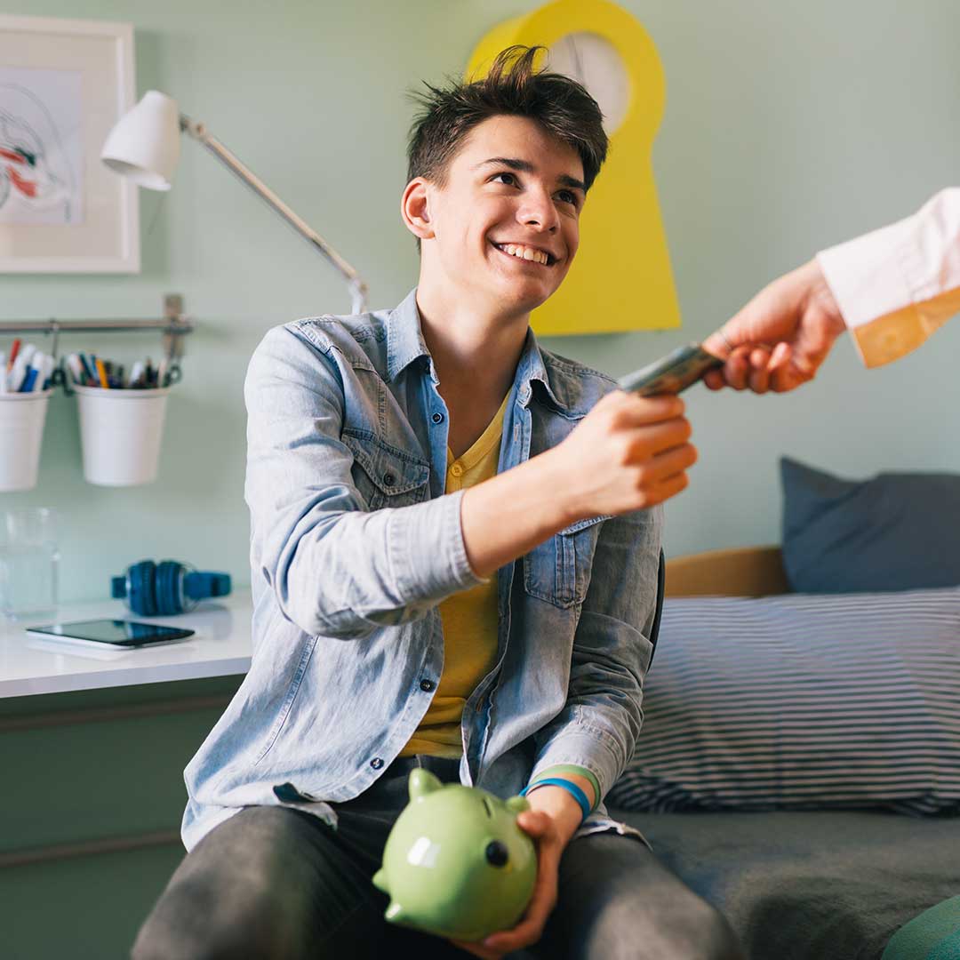 Teenager mit Sparschwein