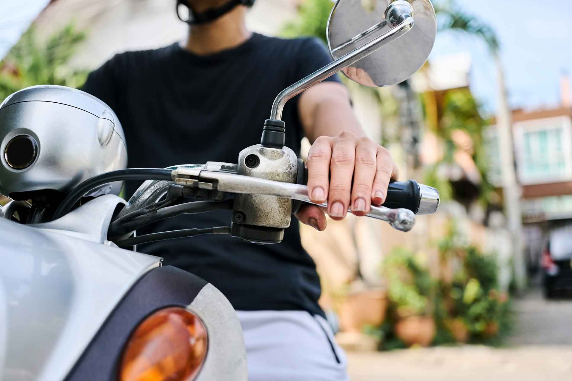 Nahaufnahme eines Roller-Lenkers mit einer Hand