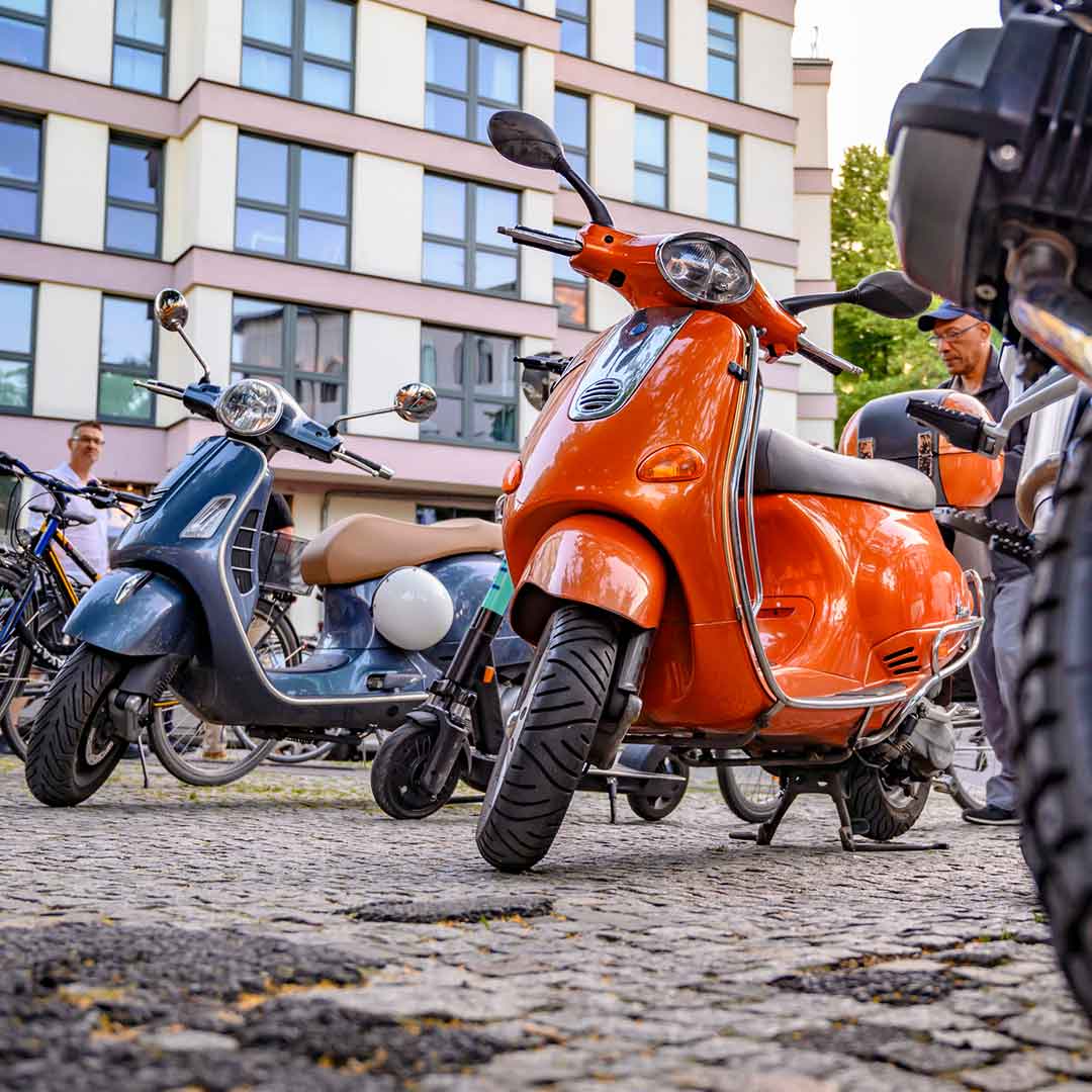 Zwei bunte Roller stehen vor einem Gebäude