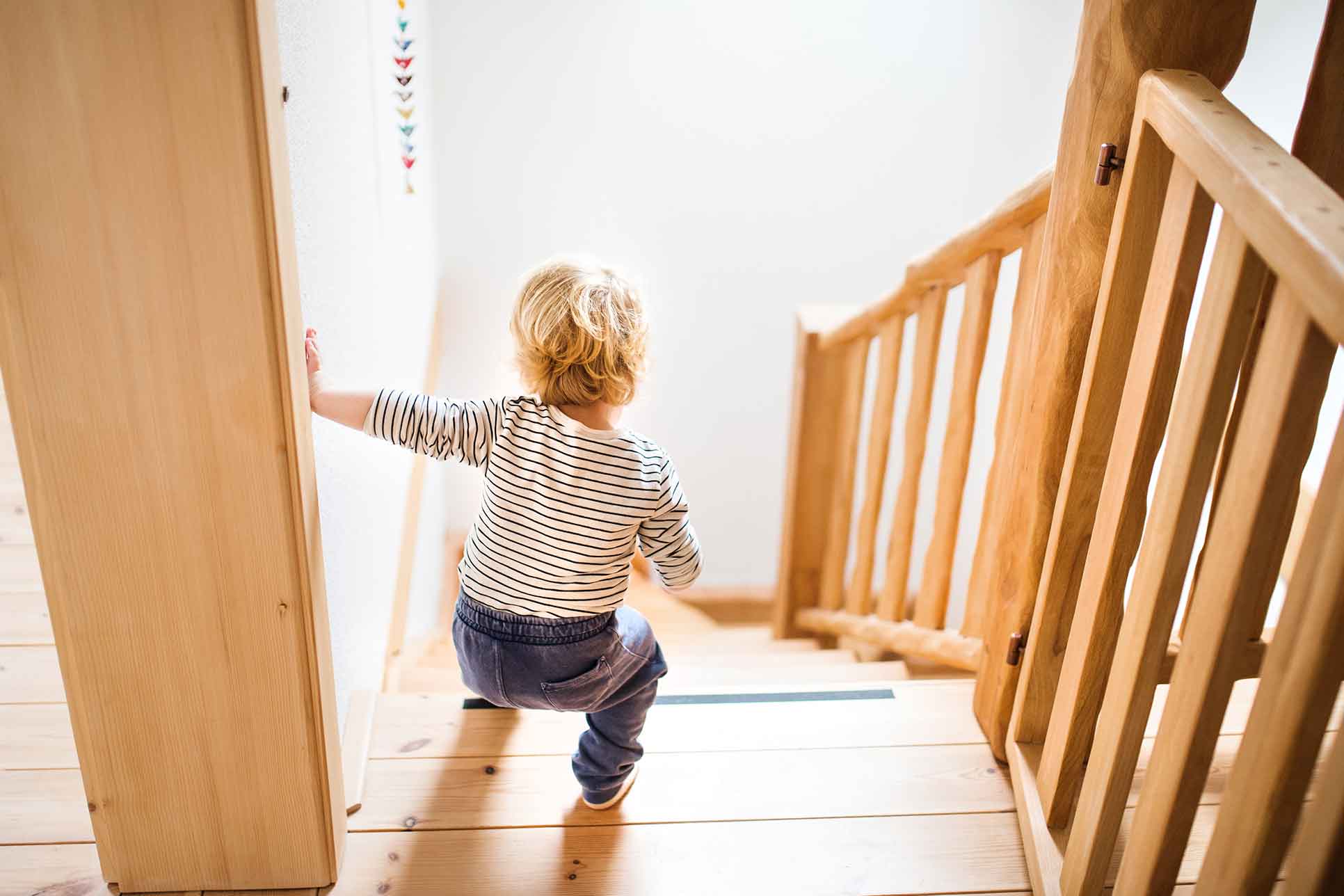 Kleines Kleinkind, das die Treppe hinuntergeht. Gefährliche Situation zu Hause